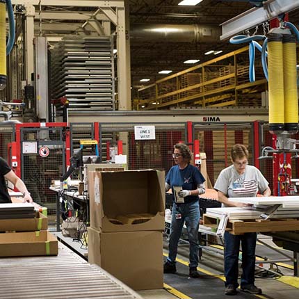Employees package items for shipment at a Haworth plant in Holland, Mich. The company is experimenting with three-day work weeks. PHOTO: EMILY ROSE BENNETT FOR THE WALL STREET JOURNAL