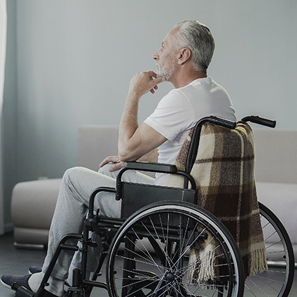 Man in wheelchair looking out nursing home window